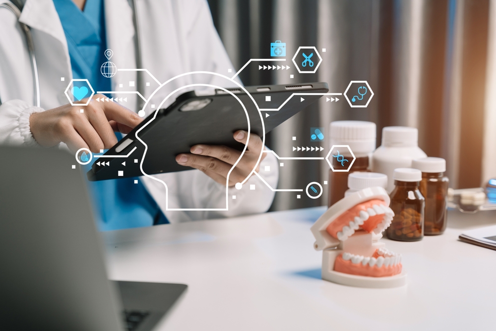 Doctor stomatologist is working on a Tablet computer and tooth model in a modern office in the morning at the desk.